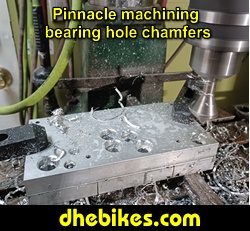 Pinnacle Innovations picture showing machining in progress of the bearing hole tapered chamfers for two Norco custom downhill bike's long travel rear suspension linkage plates made from 6061 aircraft aluminum.
